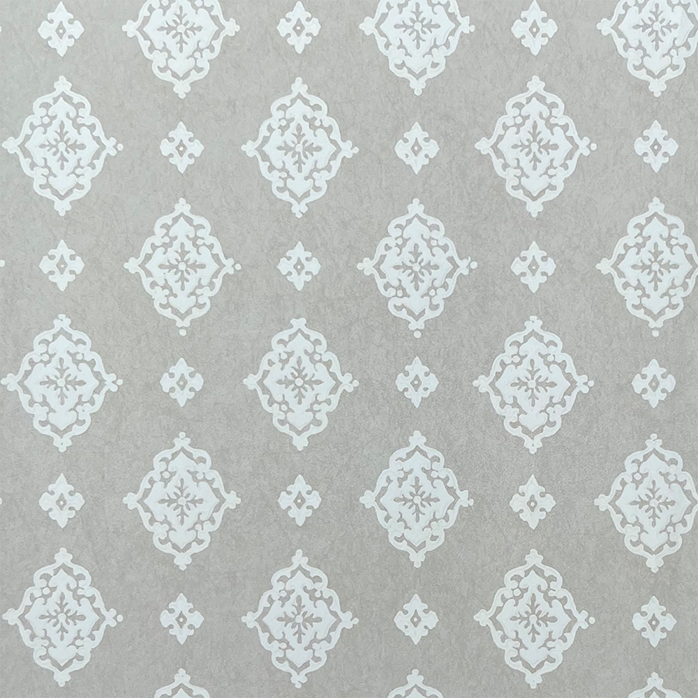 Detail of fabric in a floral damask print in cream on a light gray field.