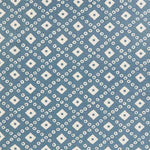 Detail of fabric in a geometric lattice print in white on a blue field.