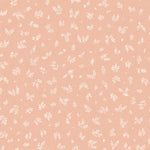 Detail of fabric in a minimal repeating leaf print in cream on a light pink field.