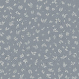 Detail of fabric in a minimal repeating leaf print in cream on a blue-gray field.
