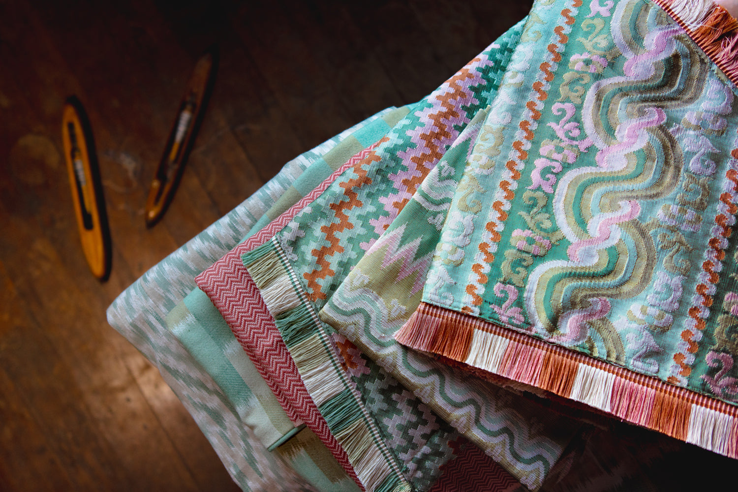 Stack of colorful fabric swatches on a wooden surface