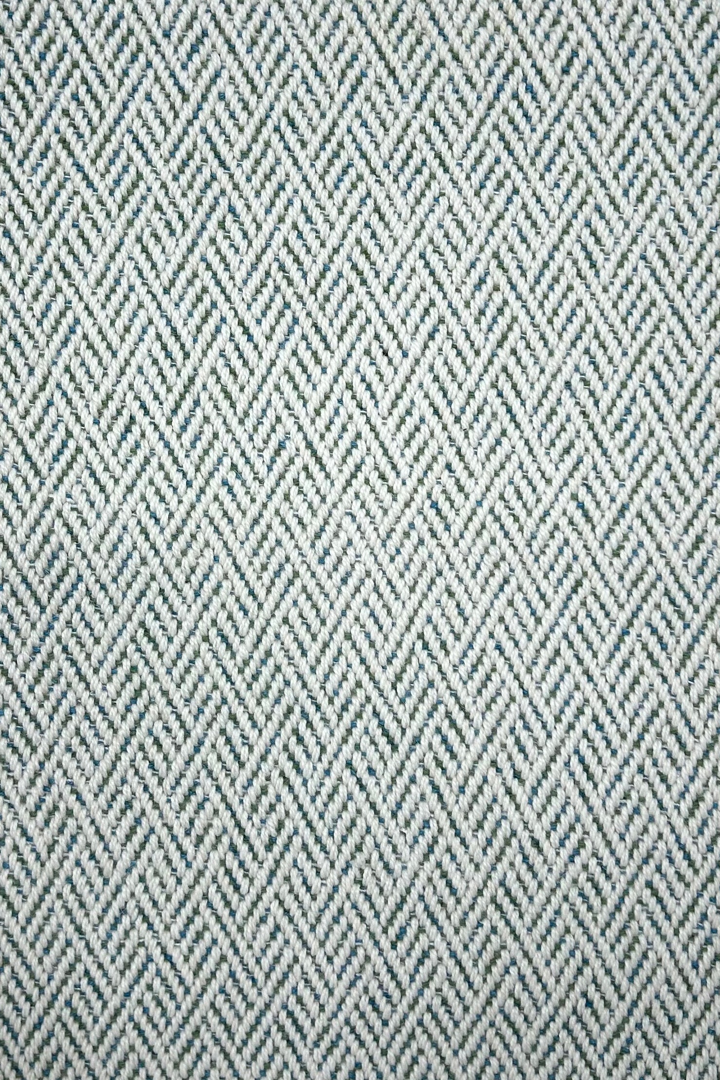 Broadloom carpet in a linear geometric design in teal and white. 
