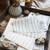 Desk scene with layered stripe fabrics and natural specimens. 