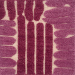 Close-up of a flatweave rug with a raised pink linear design.