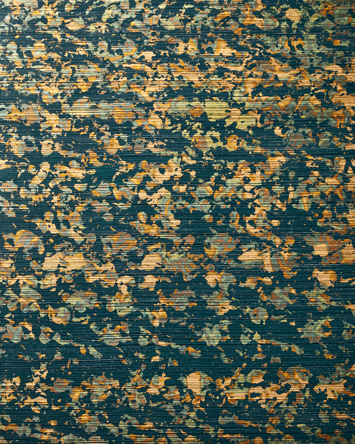 Detail of wallpaper in a paint splatter print in metallic gold and green on a navy field.