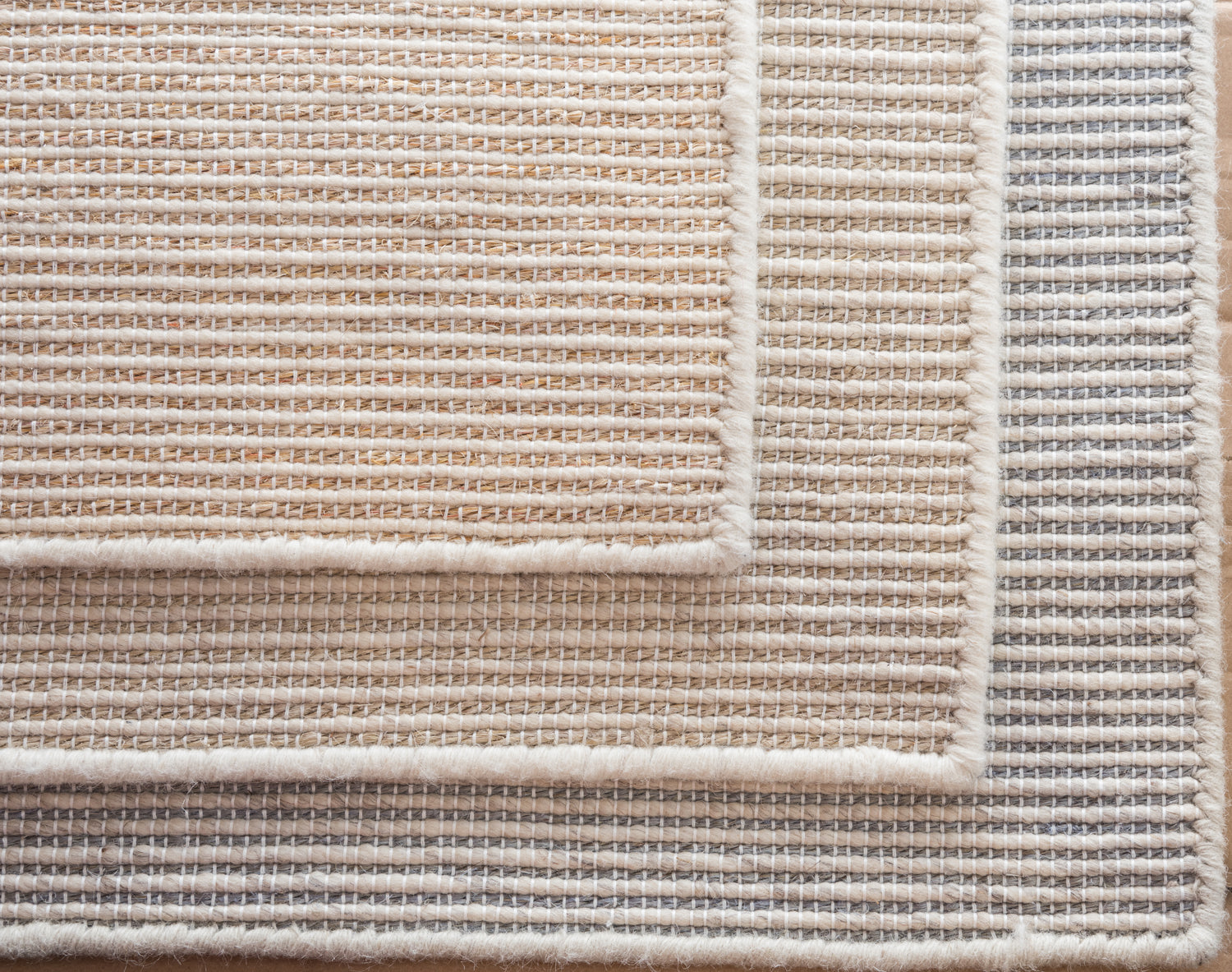 Stack of broadloom samples in neutral colors. 