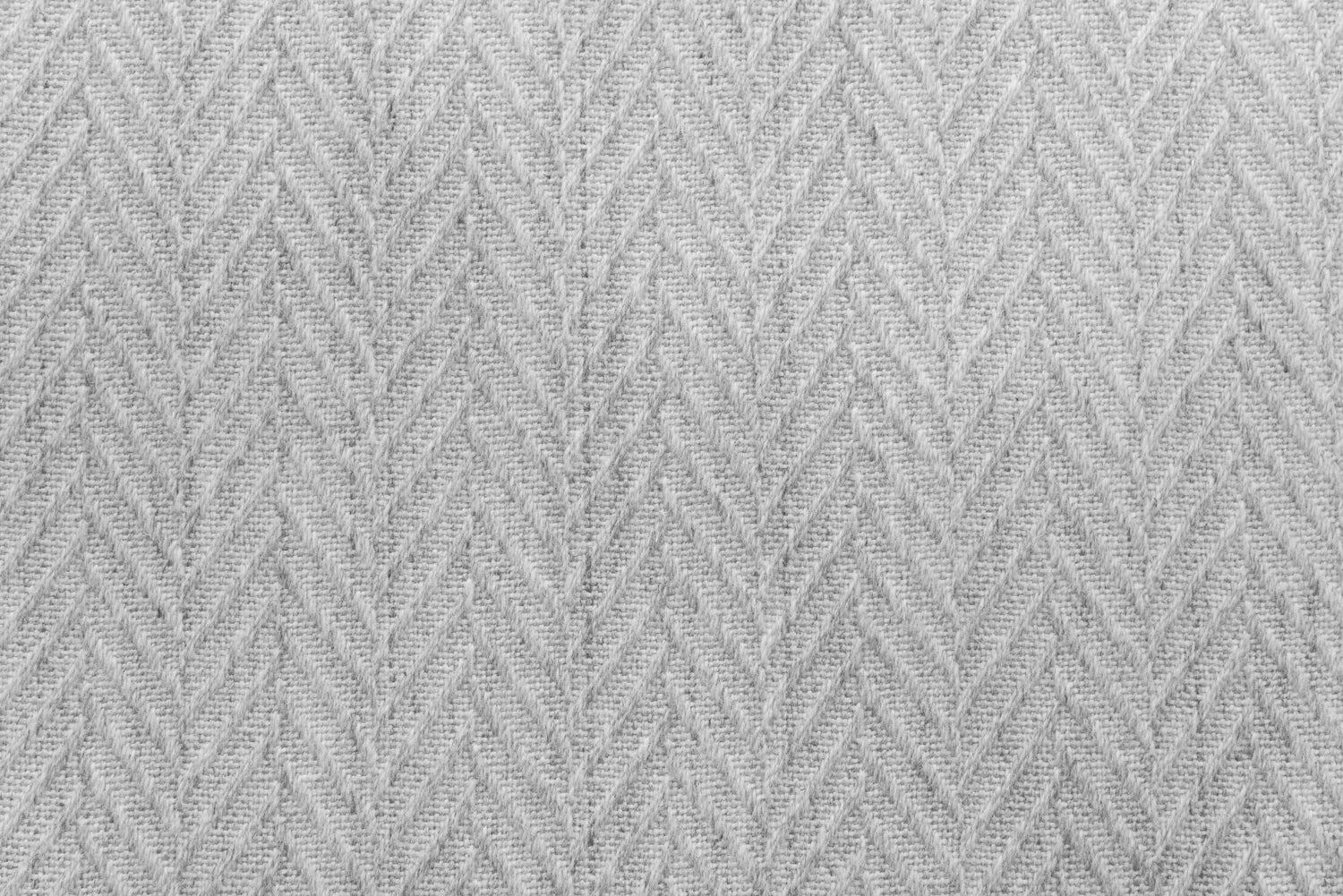 Broadloom carpet in a dimensional herringbone pattern in light grey. 