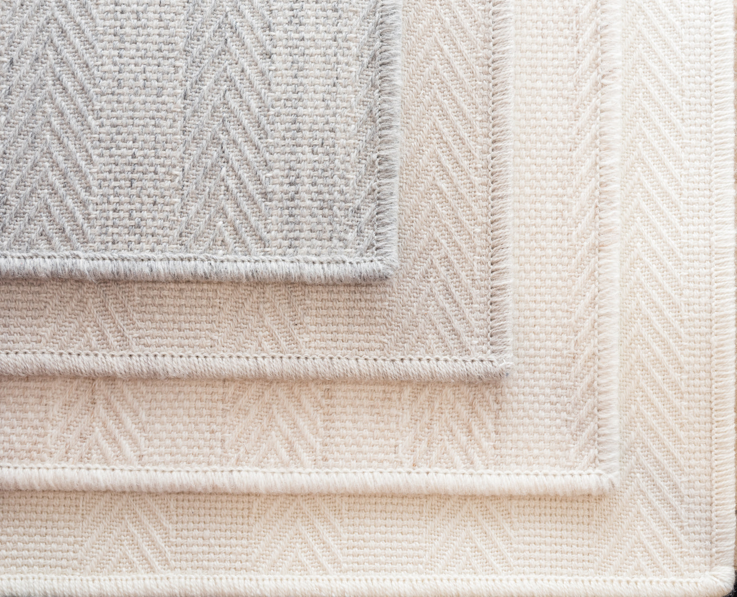 Stack of broadloom carpet samples in grey, ecru, oat and natural. 