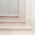 Stack of broadloom carpet samples in grey, ecru, oat and natural. 