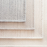 Stack of broadloom carpet samples in grey, ecru, oat and natural. 