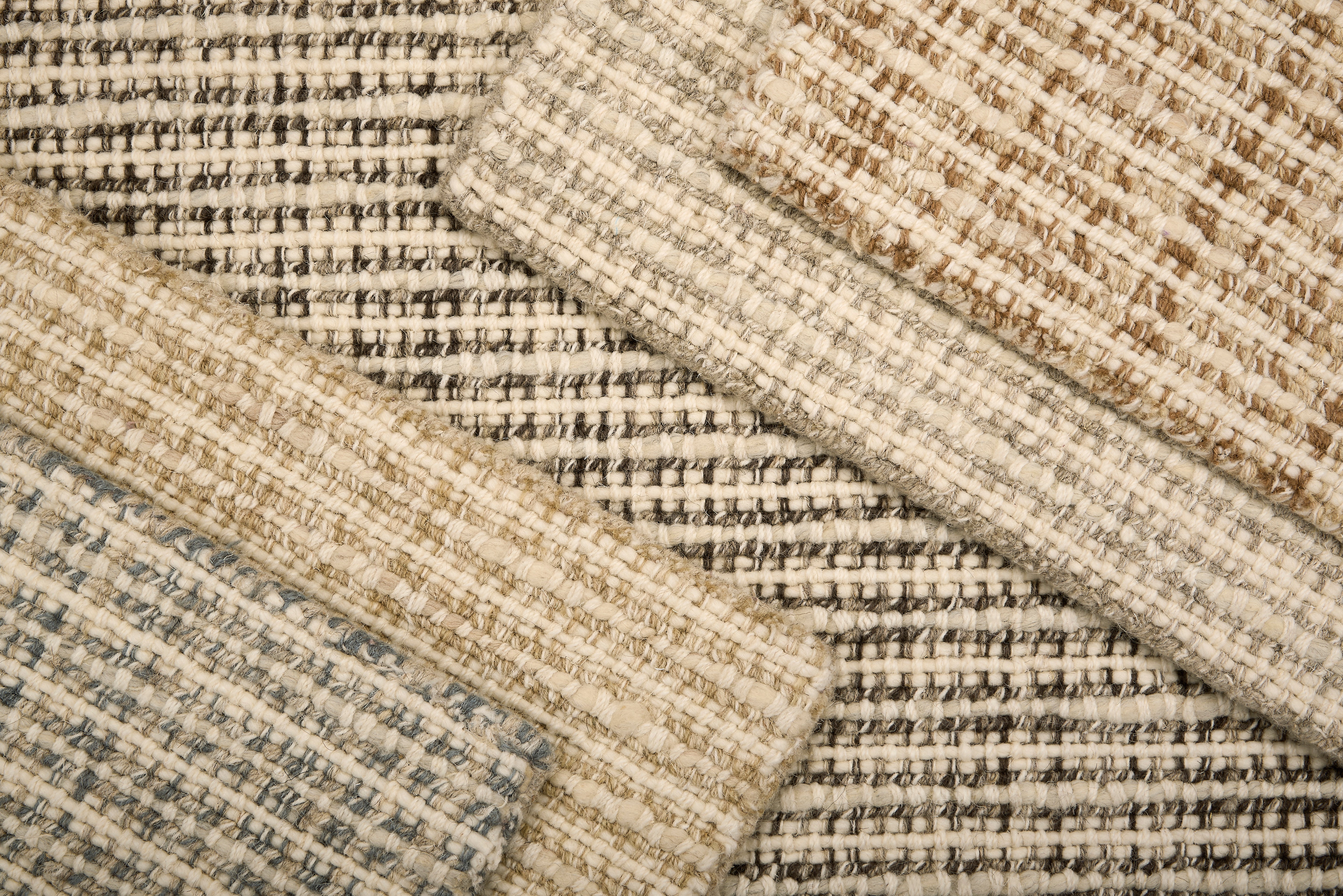 Array of Broadloom carpet samples with textural weave in neutral colors. 
