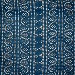 Detail of fabric in a dotted geometric stripe in cream on a navy field.