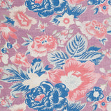 Detail of a linen fabric in a detailed floral pattern in cream, blue and pink on a purple field.