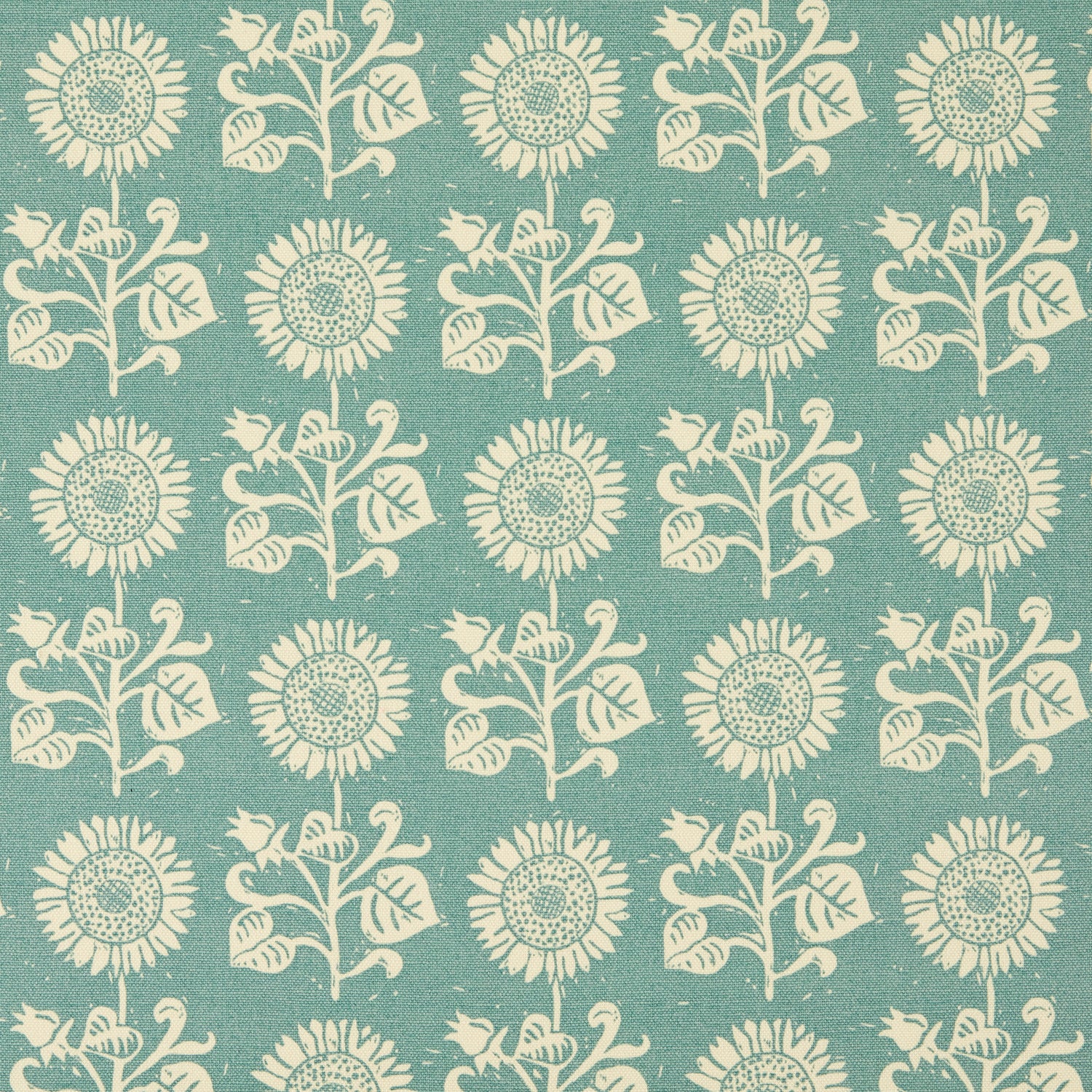 Detail of fabric in a repeating sunflower print in cream on a blue field.