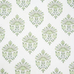 Detail of fabric in a floral paisley print in shades of green on a white field.