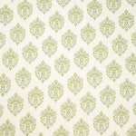 Detail of fabric in a floral paisley print in shades of green on a white field.
