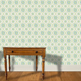 A wooden end table stands in front of a wall papered in a playful floral stripe in blue and green on a light blue field.