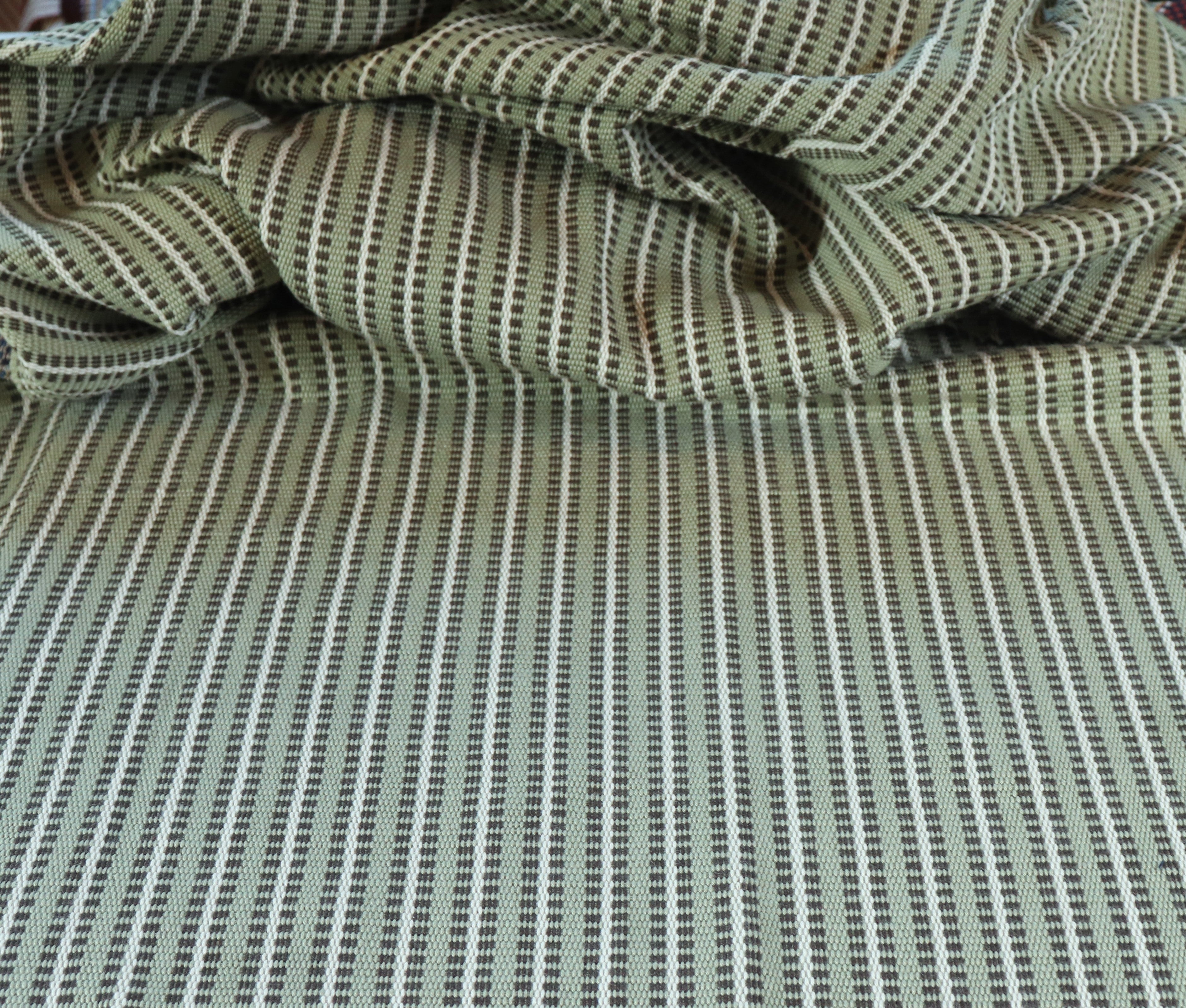 Draped textile fabric with a green and cream striped pattern