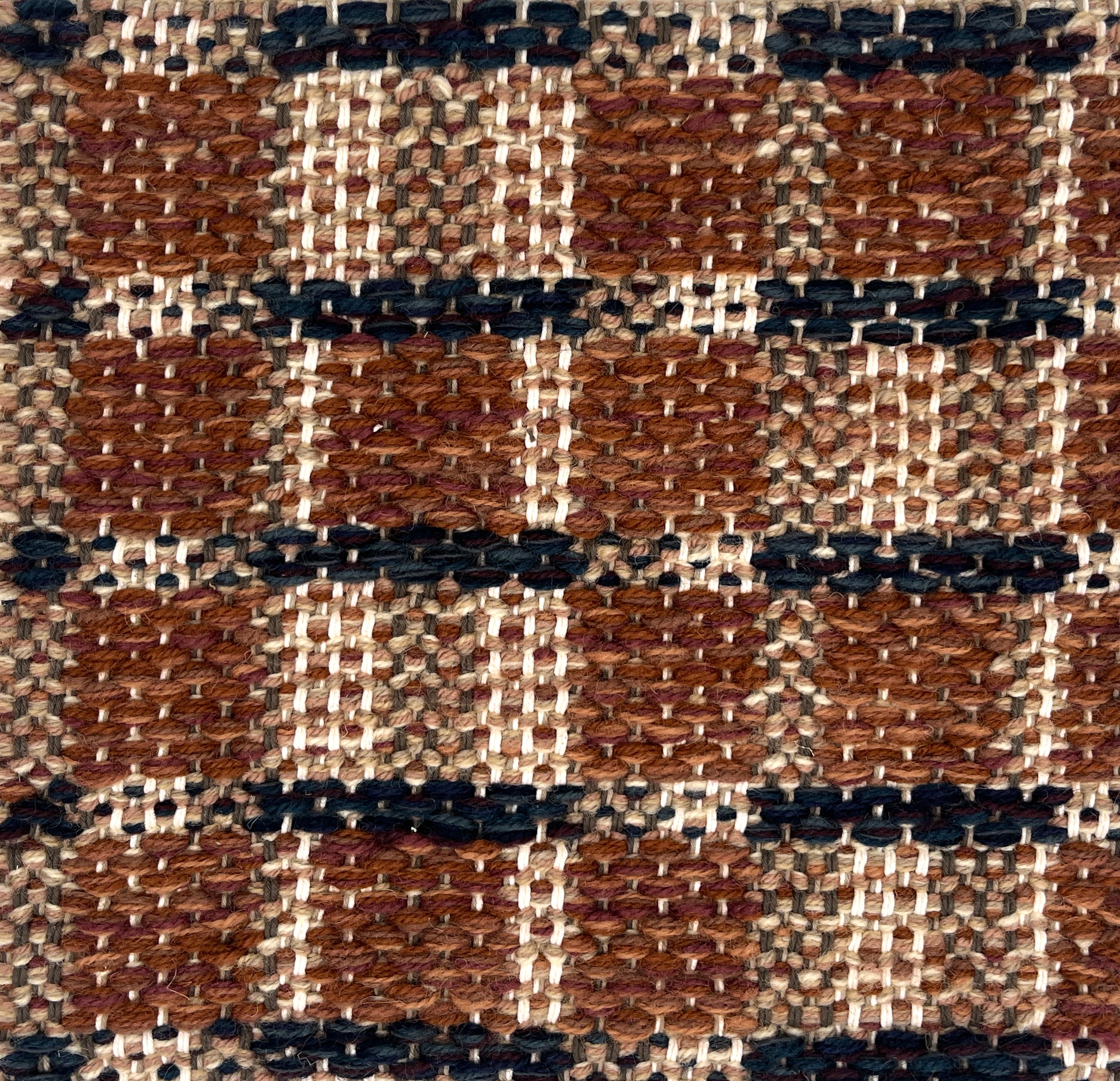 Close-up of a woven plaid rug with brown, black, and beige.
