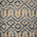 Handwoven carpet in a complex geometric lattice design in shades of blue on a beige field. 