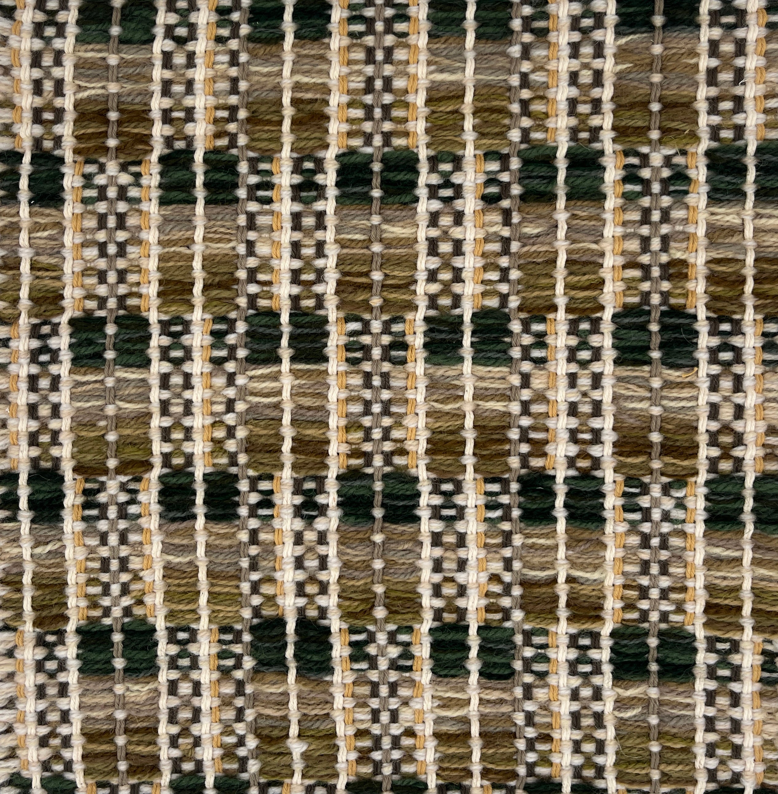 Close-up of a woven rug  with a geometric checker pattern in earthy tones.