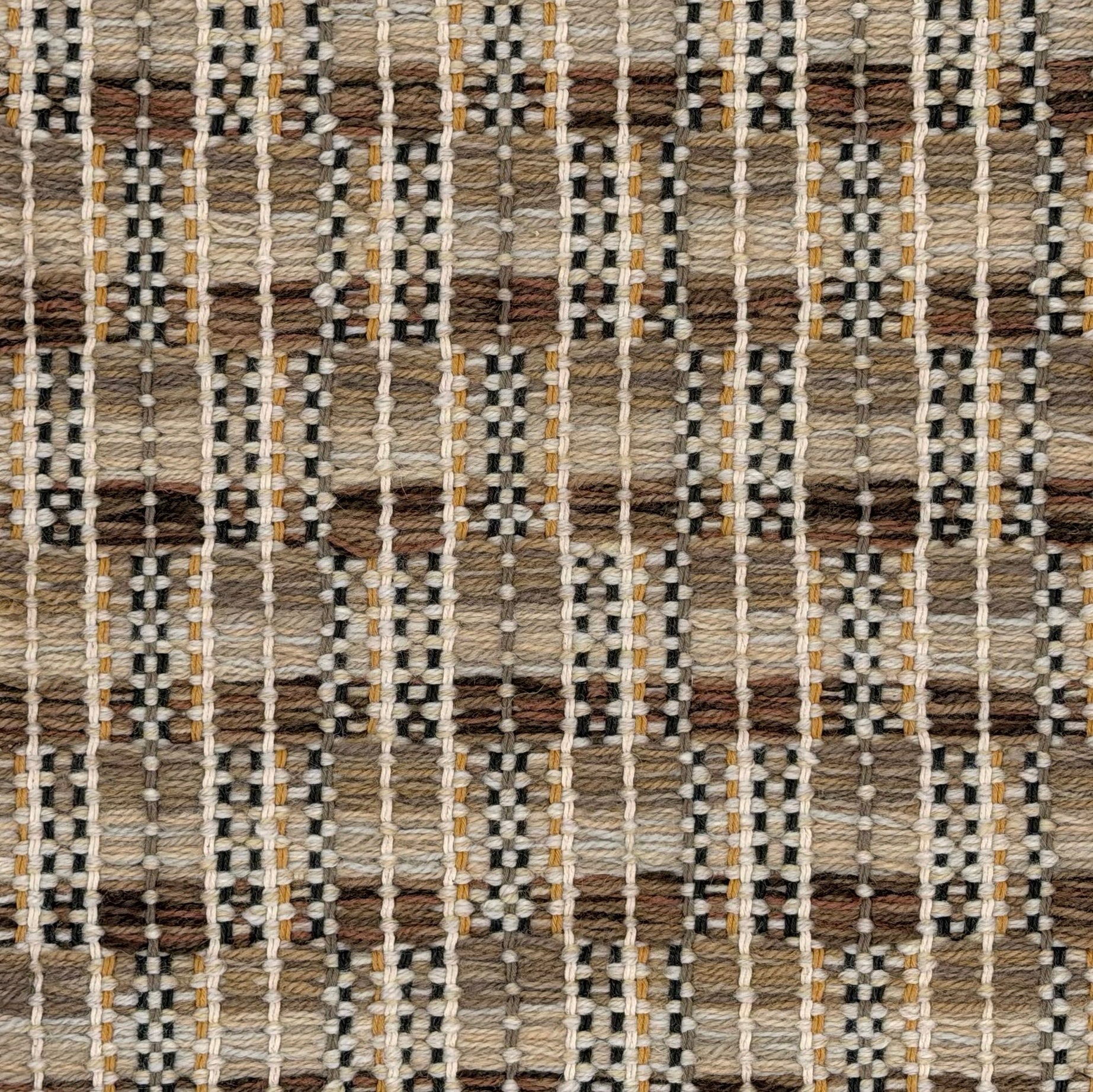A close-up of a woven rug featuring a checkerboard plaid design with shades of tan, beige and brown.