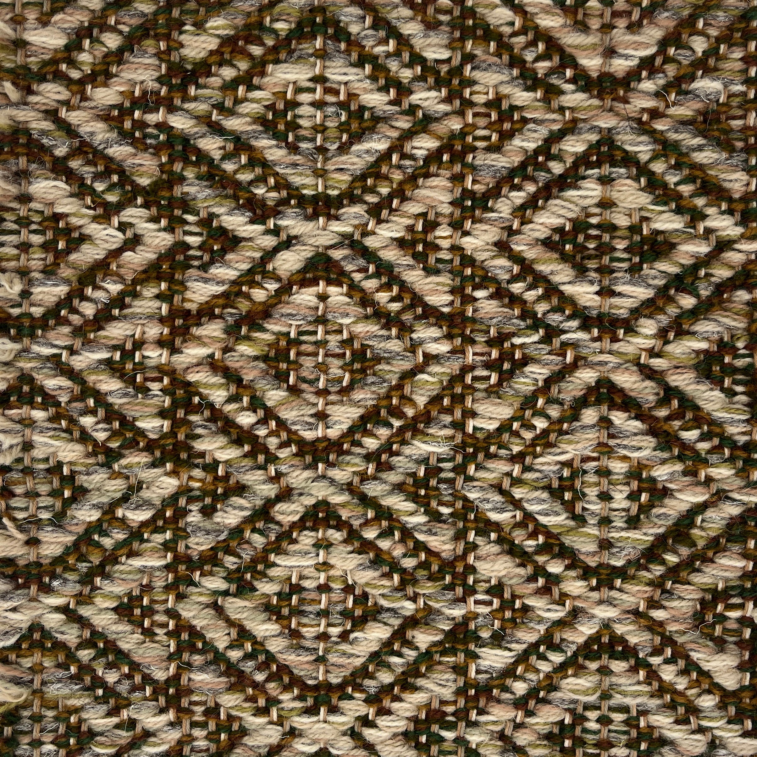 Close-up of a woven rug with diamond pattern in shades of brown.