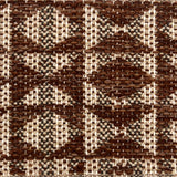 Close-up of a woven rug with geometric pattern in shades of brown.