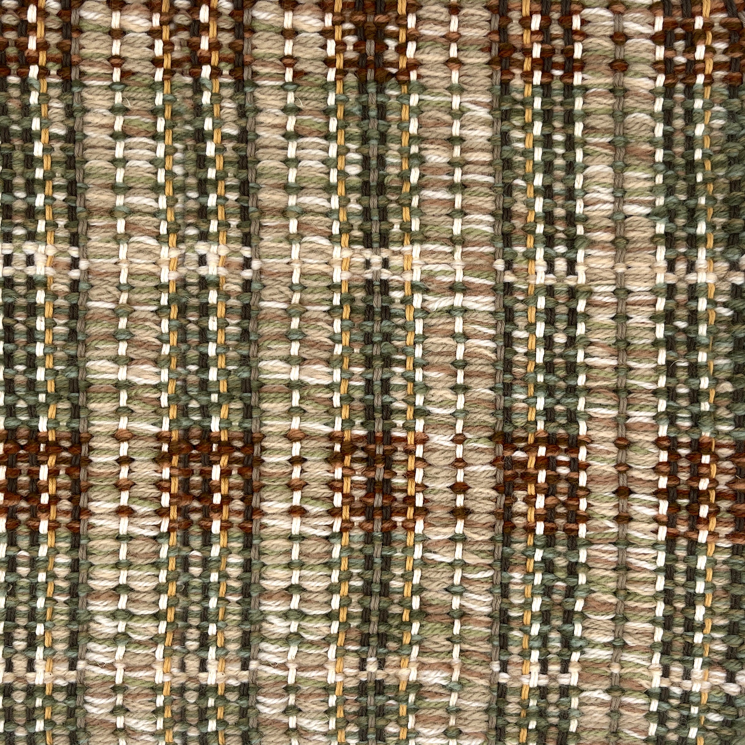 Close-up of a textured brown, green and beige plaid woven rug. 