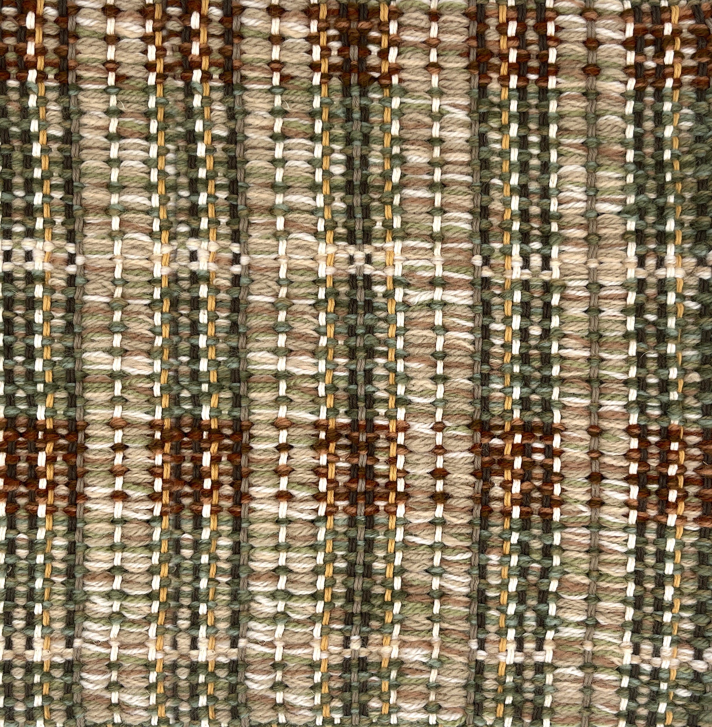 Close-up of a textured brown, green and beige plaid woven rug. 