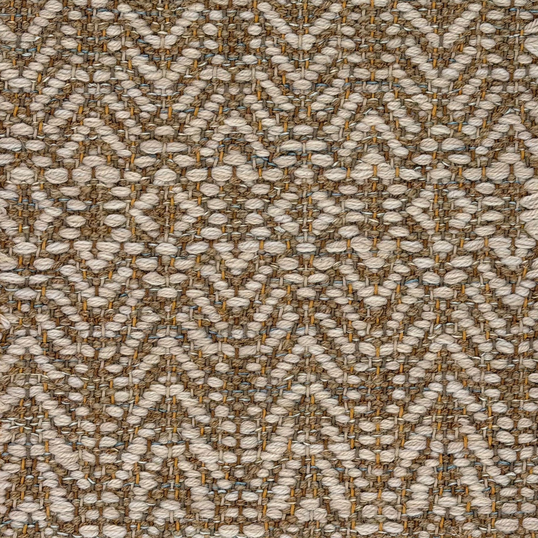 Handwoven rug detail in a linear diamond design in tonal neutral browns.