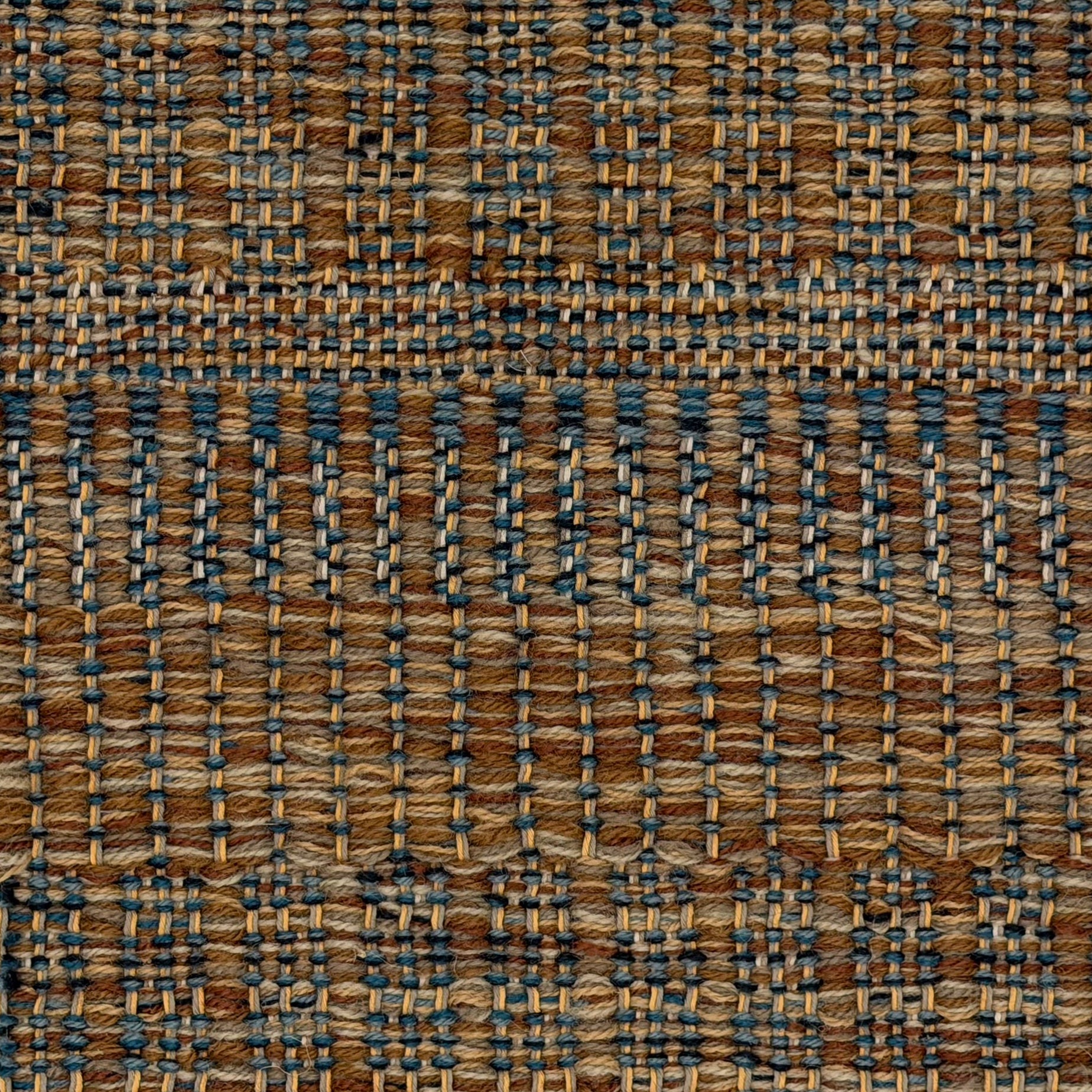A close-up of a woven rug featuring a stacked stripe design in brown, blue and tan. 