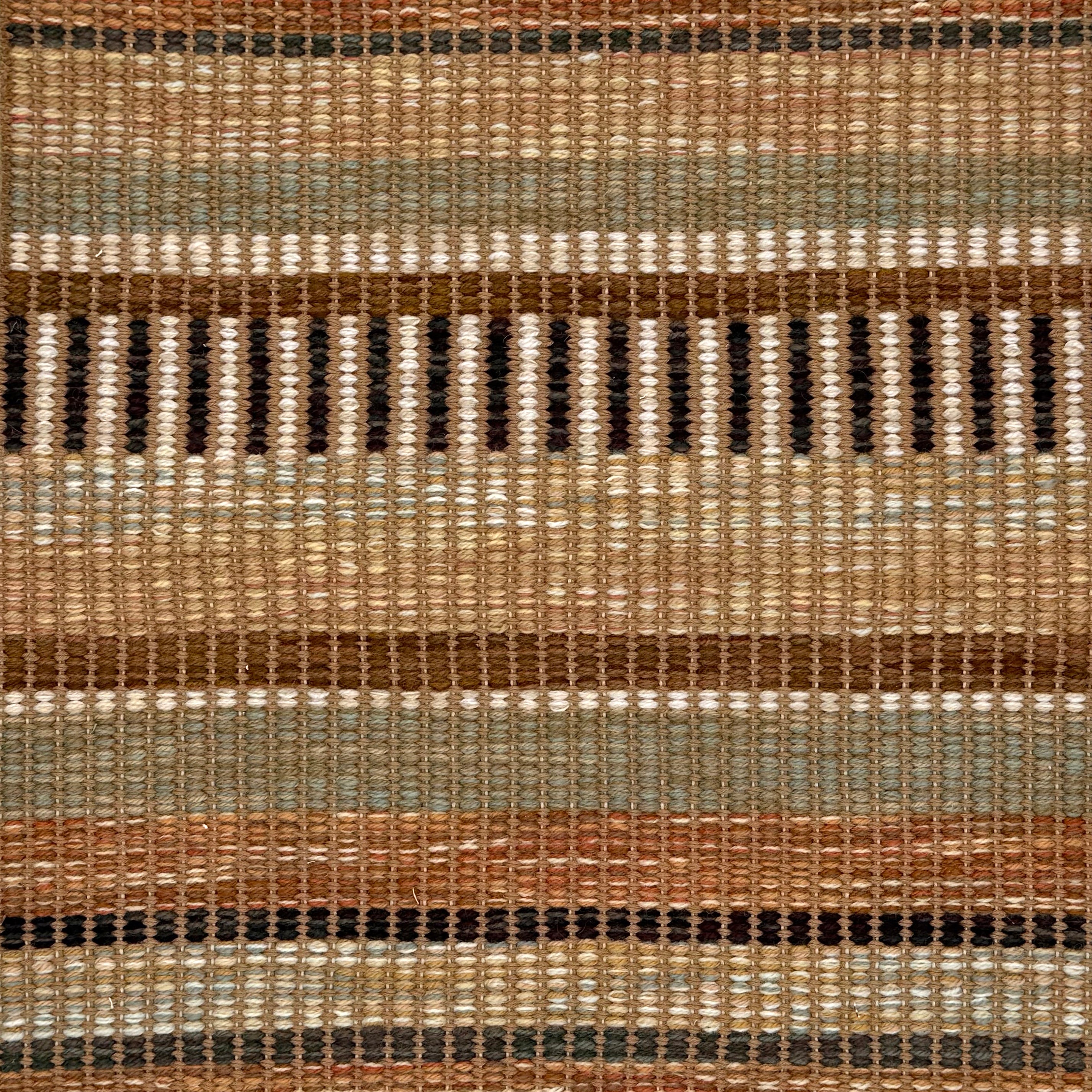 A close-up of a woven rug featuring a stacked stripe design in tan, sage green, brown and cream.