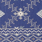 Rug with white geometric pattern on a blue background
