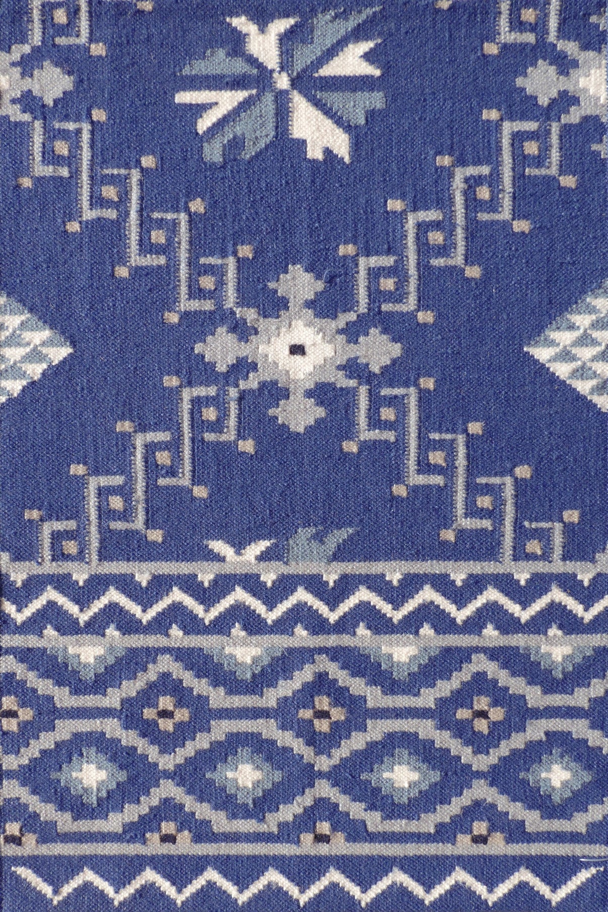 Rug with white geometric pattern on a blue background