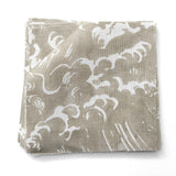 Fabric swatches in a playful wave print in white on a pale grey-green watercolor field.