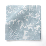 Fabric swatches in a playful wave print in white on a pastel blue watercolor field.