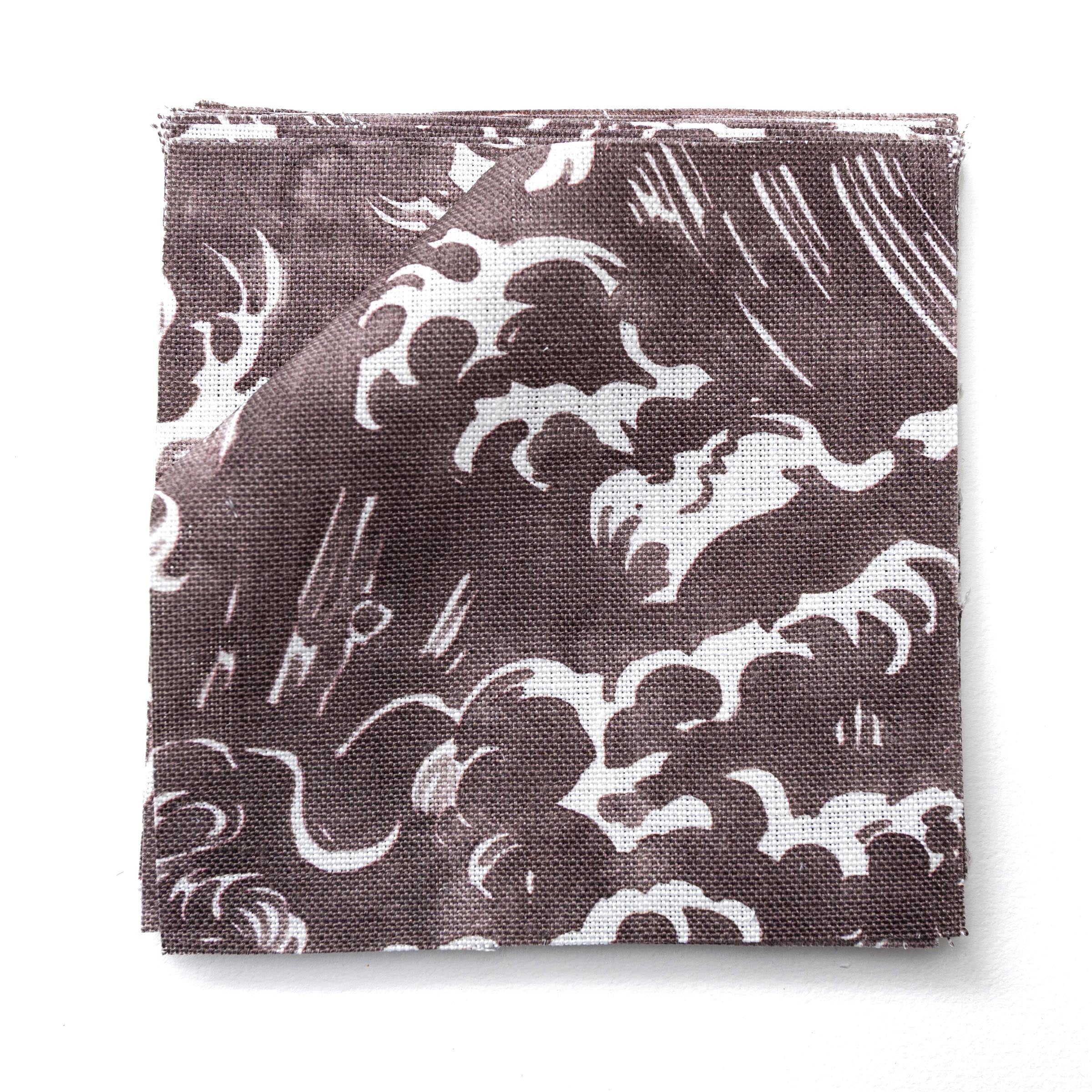 Fabric swatches in a playful wave print in white on a warm dark grey watercolor field.