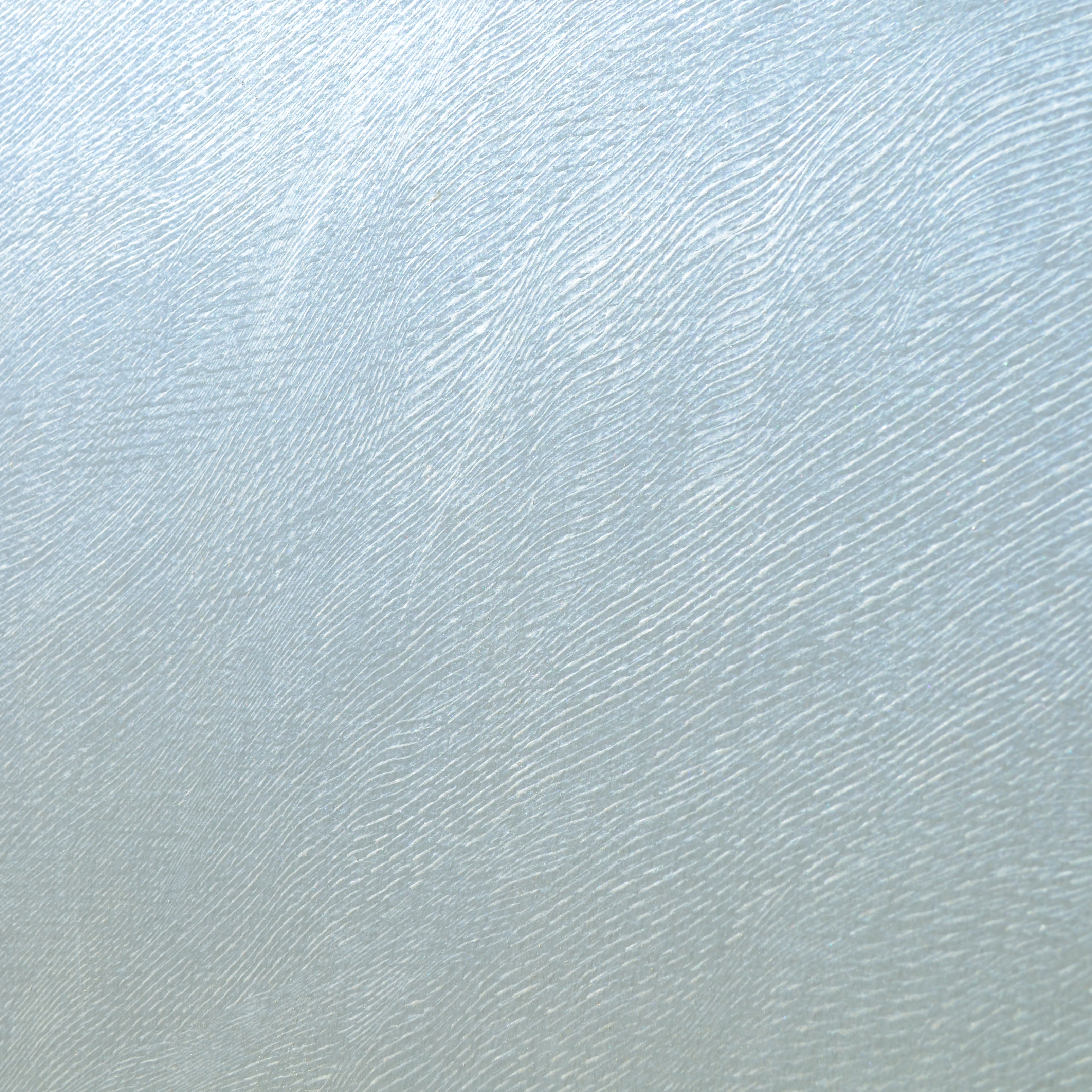 Detail of a wallpaper in an abstract ridged texture in metallic sky blue.