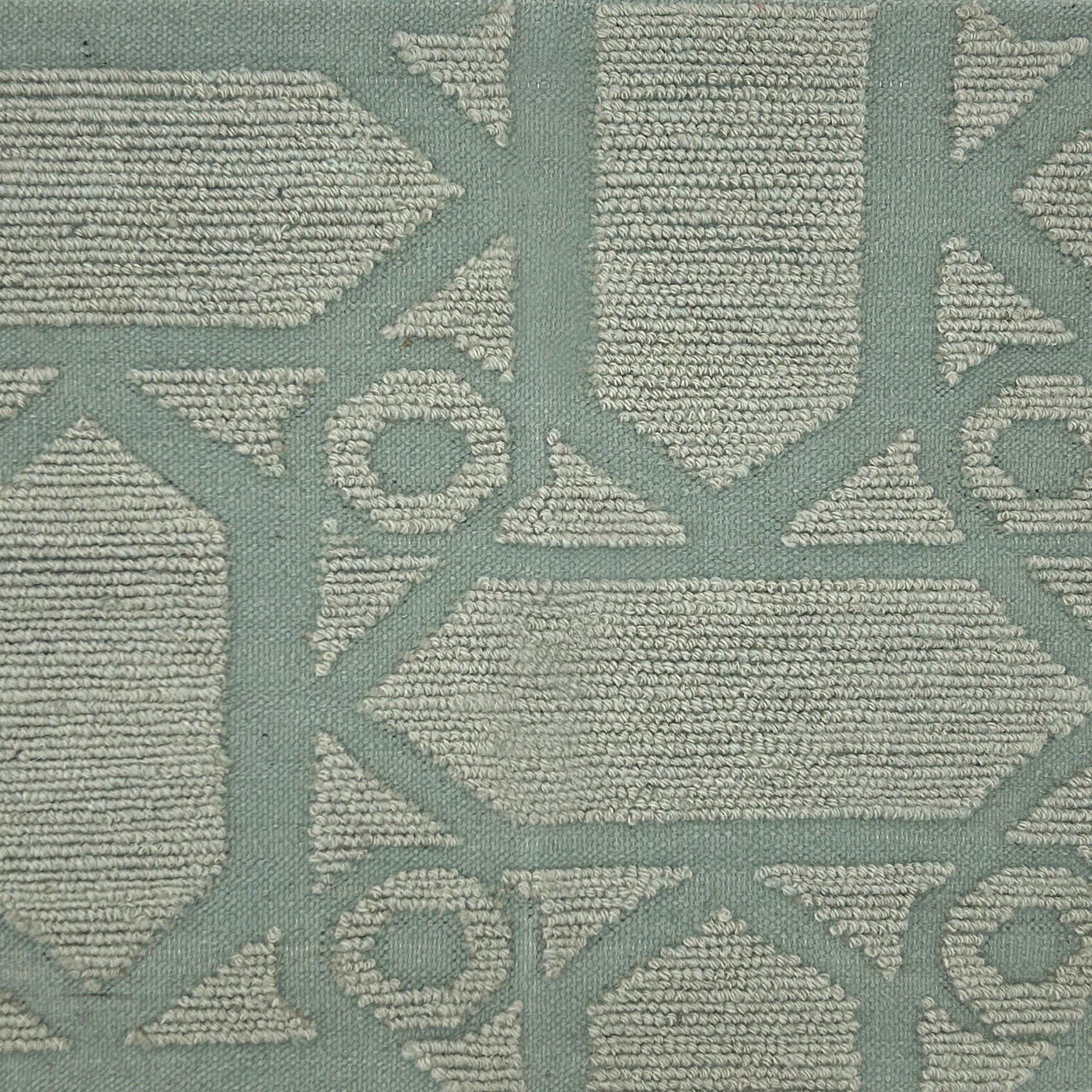 Handmade rug with geometric pattern in light turquoise