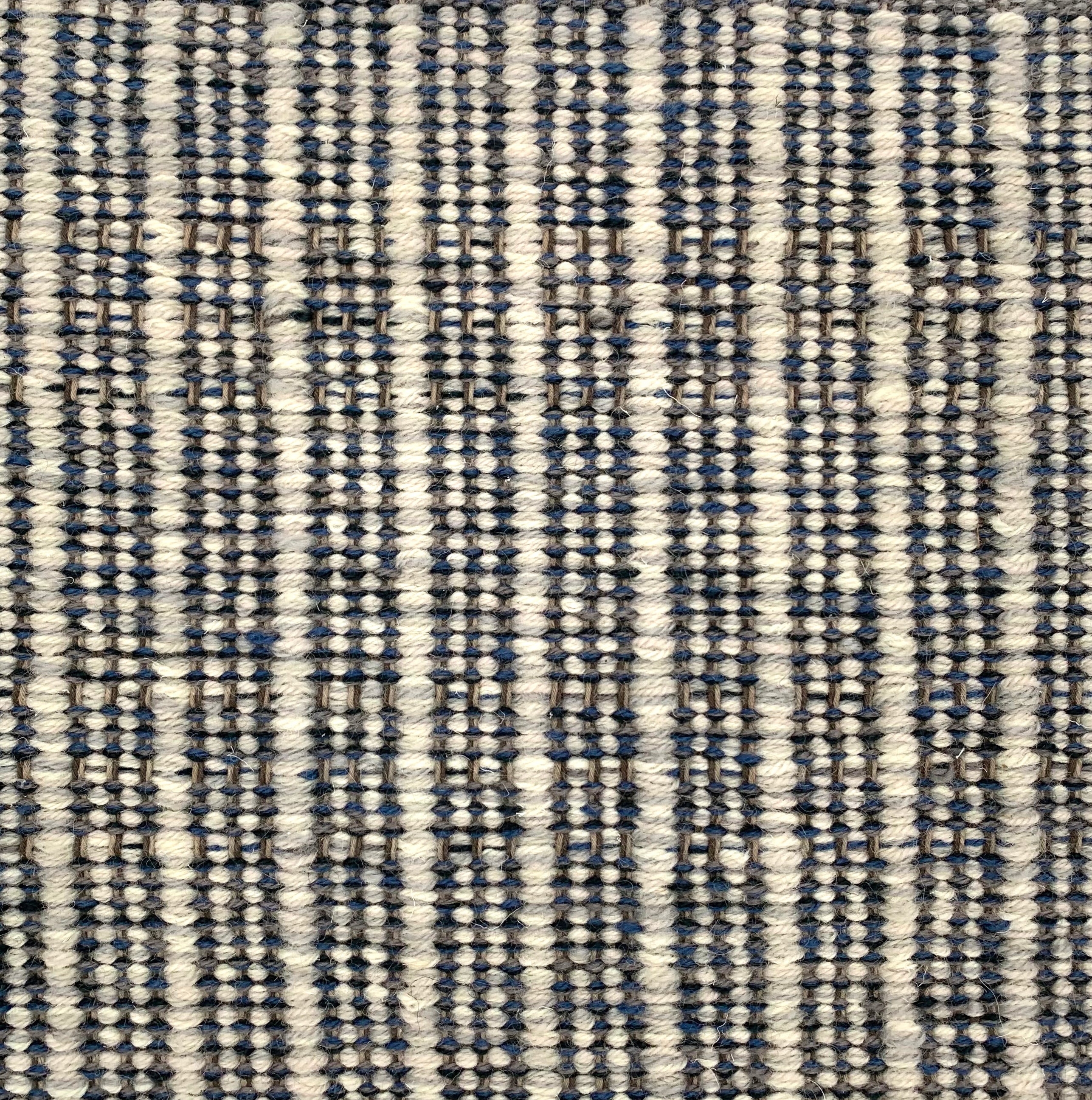 Handwoven rug detail in a stripe design in black and white