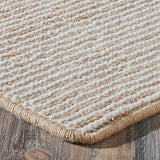 Close-up of a textured beige rug on a wooden floor