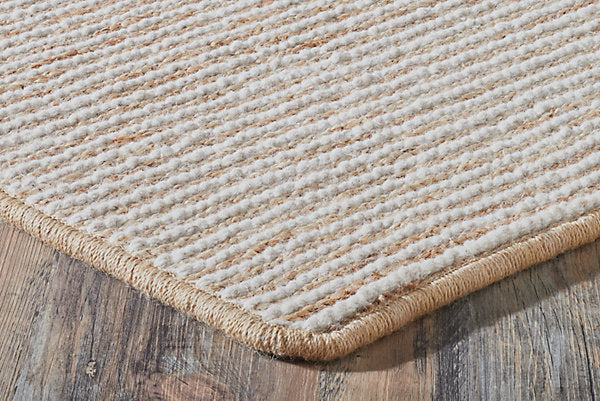 Close-up of a textured beige rug on a wooden floor