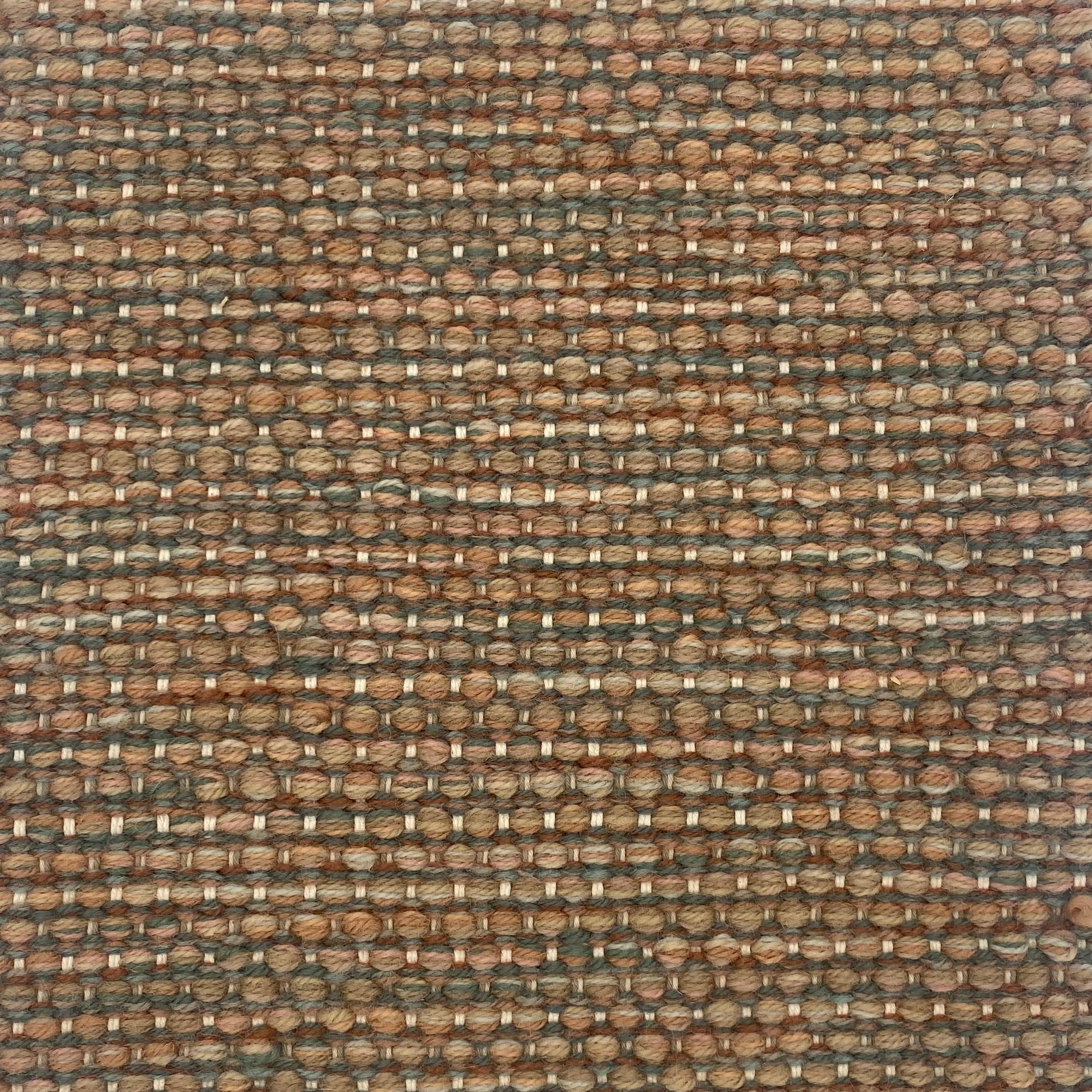 Textured handwoven carpet with a mix of brown, dusty clay ink and green.