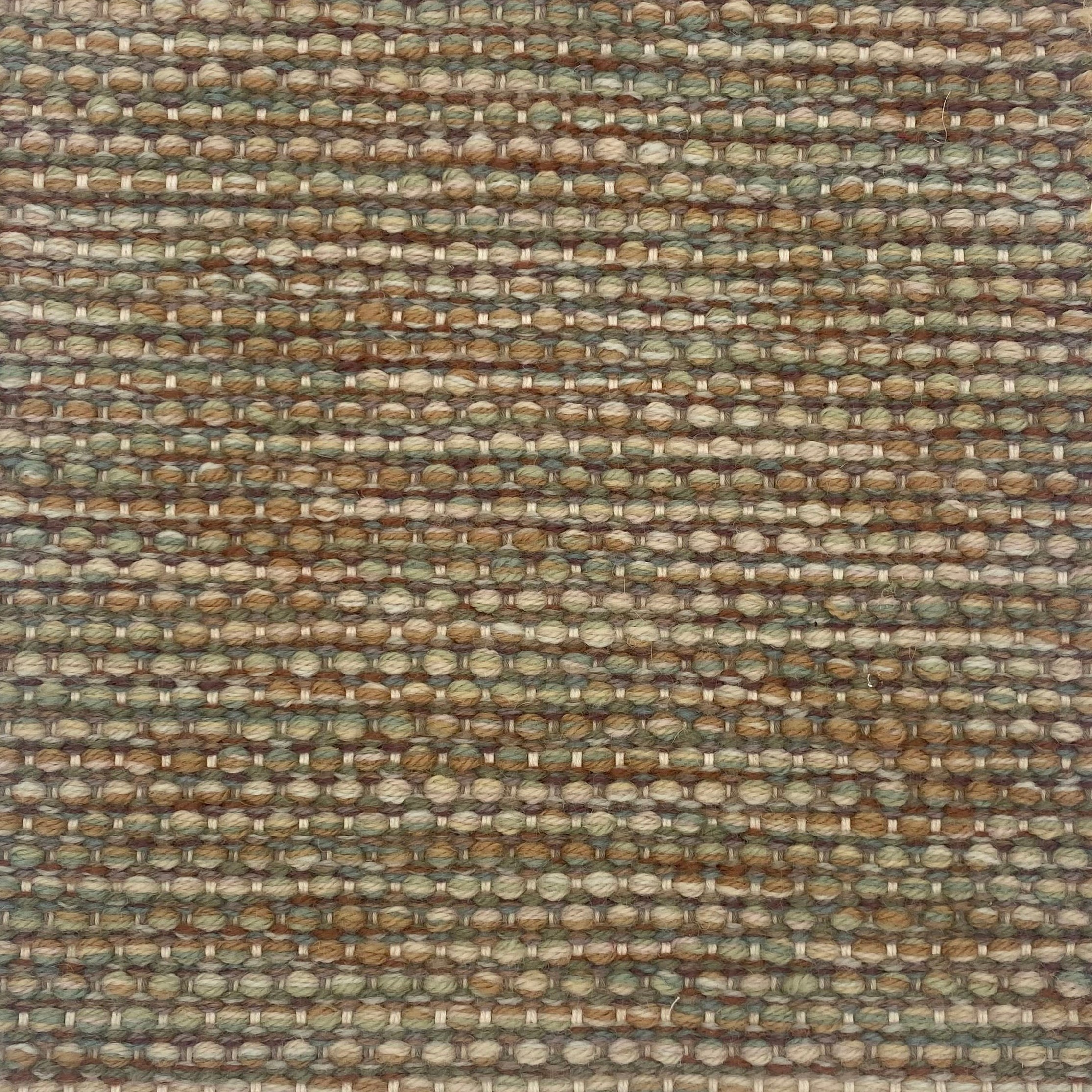 Textured handwoven carpet with a mix of brown, sage green and tan.