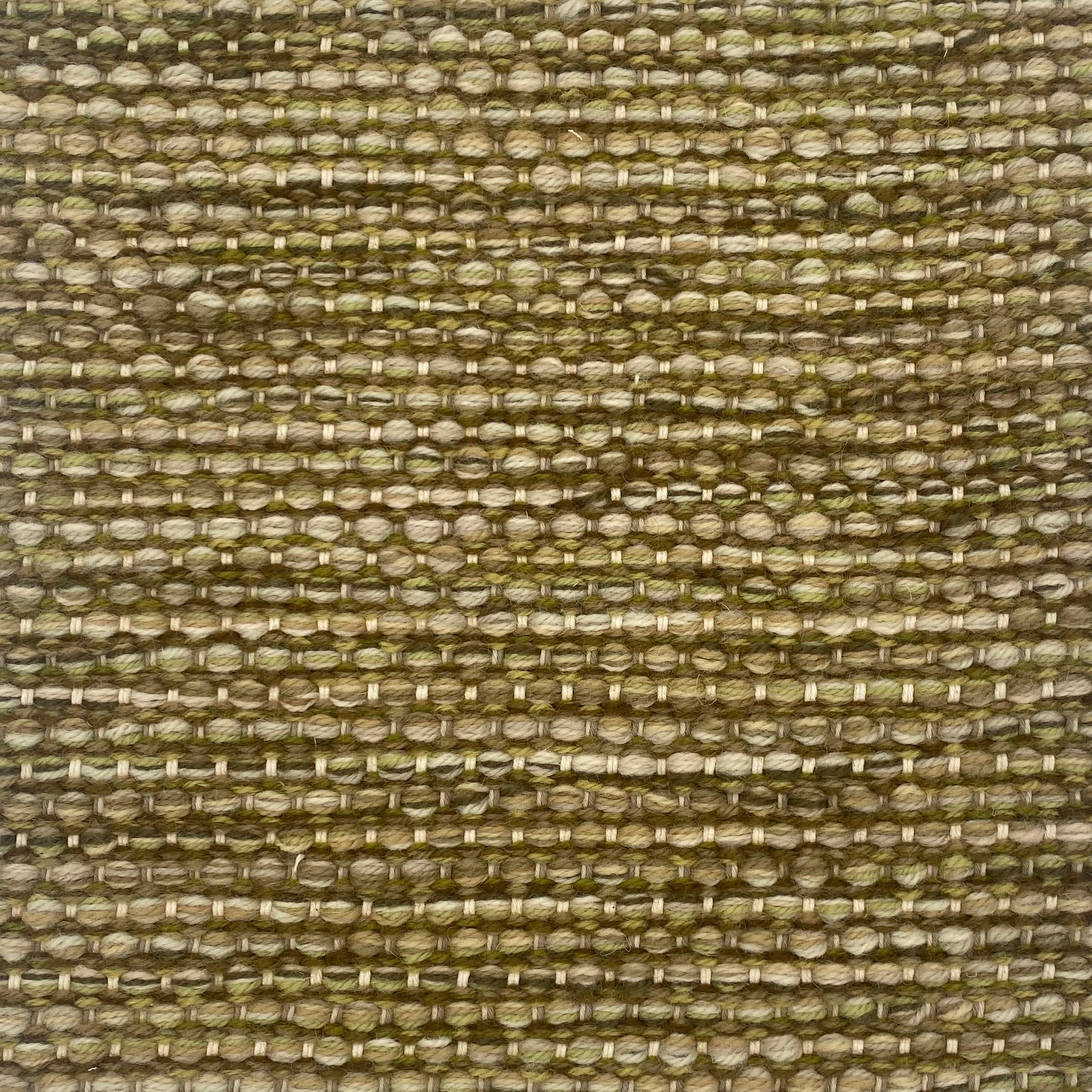 Textured handwoven carpet with a mix of green yarns. 
