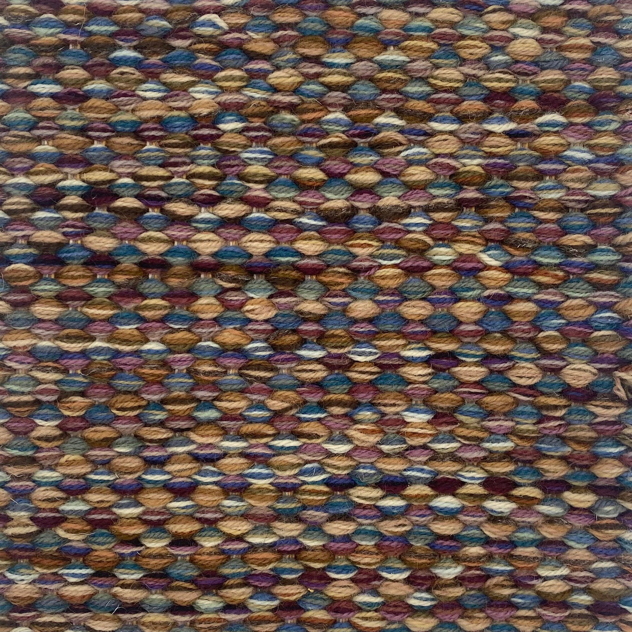 Textured handwoven carpet with a mix of purple, teal and brown.