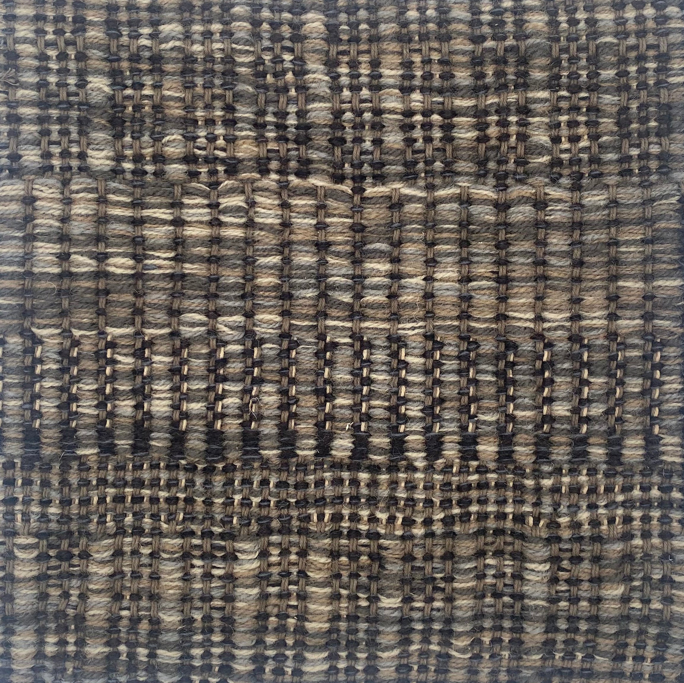 Close-up of a textured rug in sahdes of grey and black