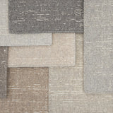 Layered samples of broadloom carpet in neutral colors. 