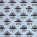 Pattern of purple and green floral designs on a light blue background